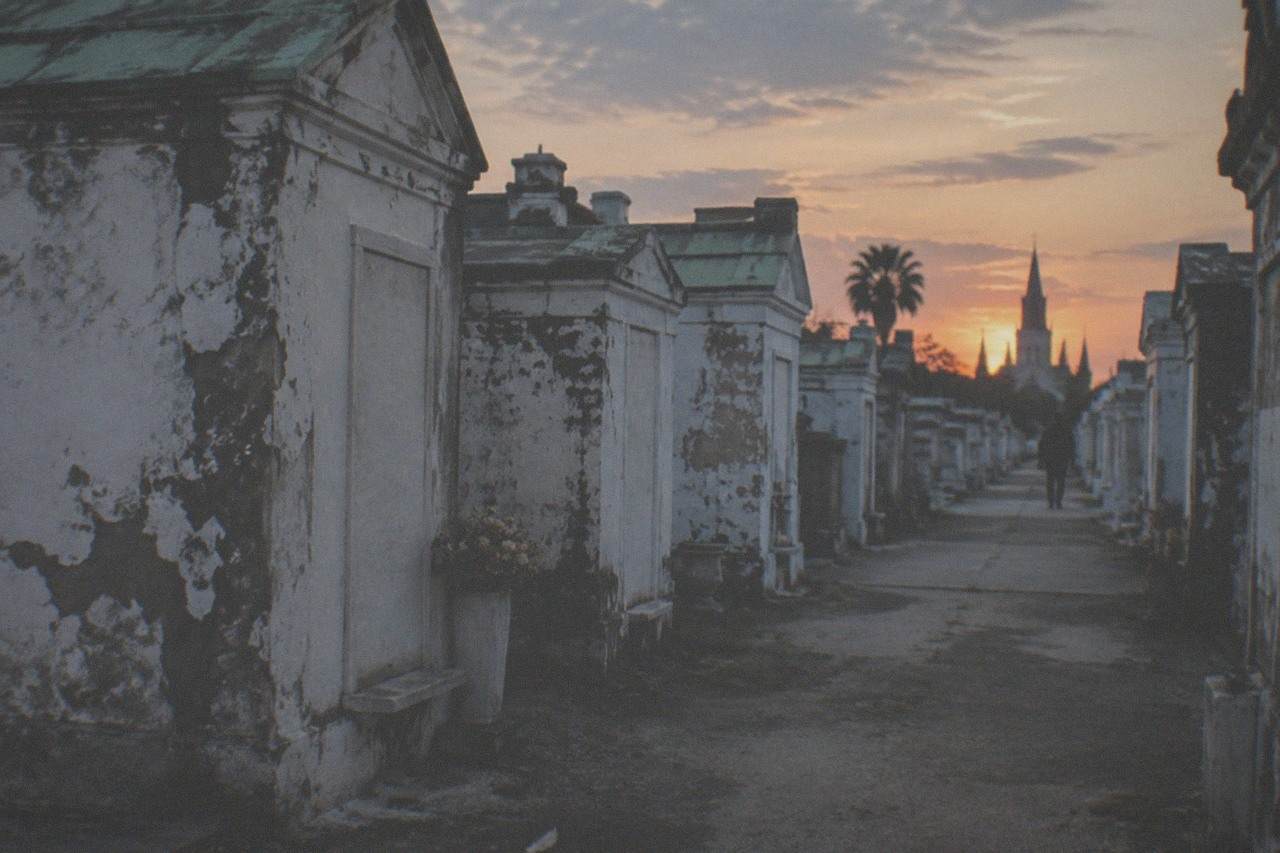 Rows of weathered above-ground tombs in a historic New Orleans cemetery at dusk