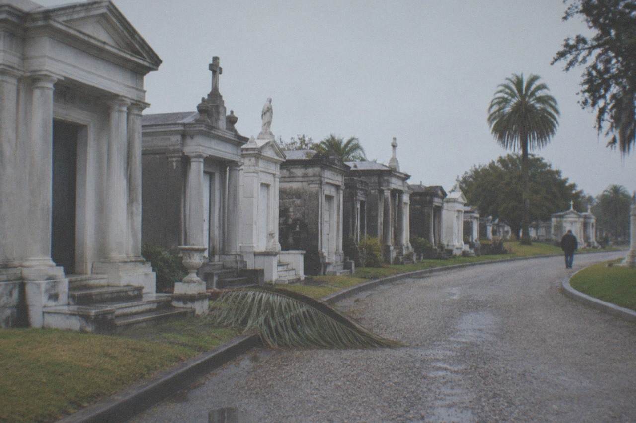 Rows of weathered above-ground tombs in a historic New Orleans cemetery under an overcast sky
