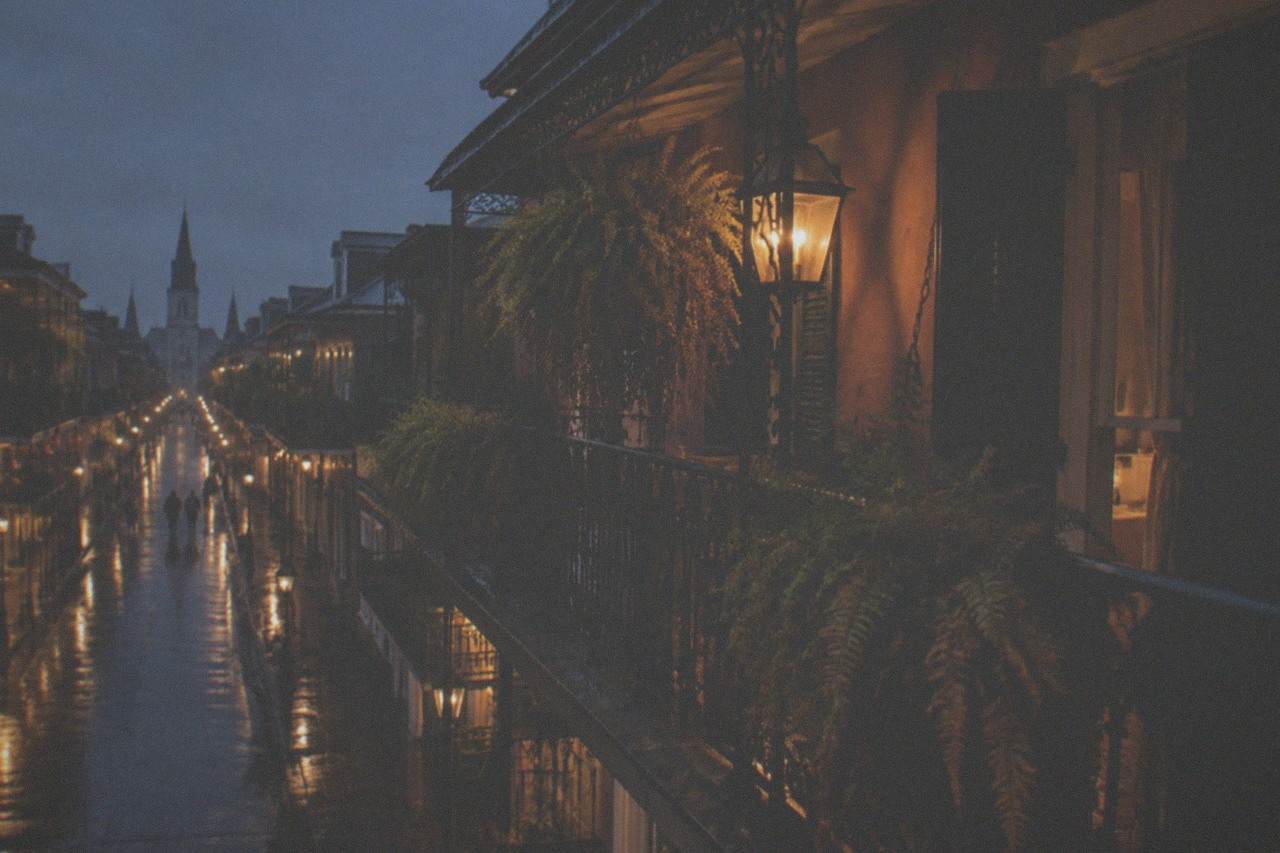 Lantern light on a French Quarter balcony with iron railings at night