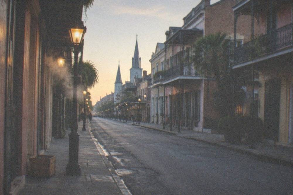 A gas-lit block of Royal Street in the French Quarter with historic townhouses and empty sidewalks