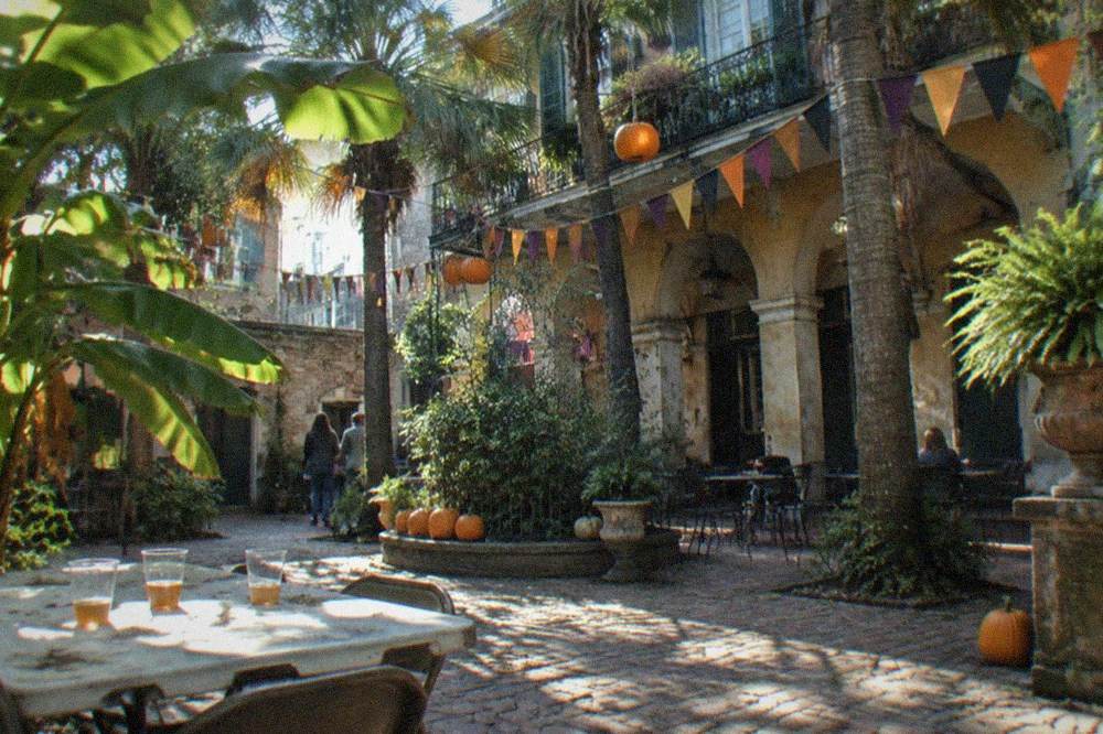 A French Market courtyard decorated for a family Halloween event with pumpkins and bunting
