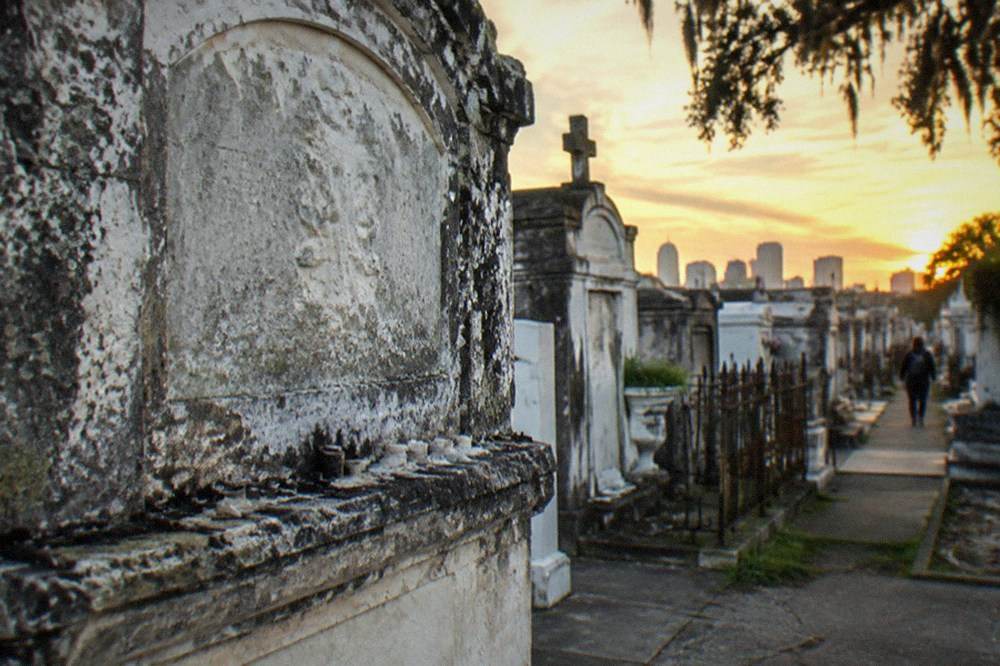 A weathered family tomb with a faded name carved into its face inside a New Orleans cemetery