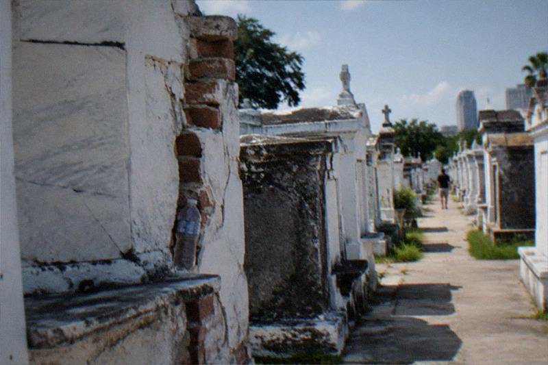 Weathered above-ground tombs in rows inside a New Orleans cemetery in daylight