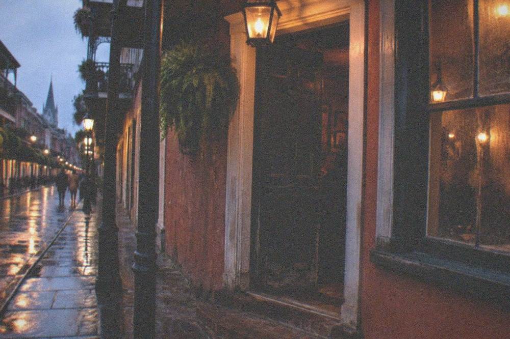 Historic French Quarter tavern doorway lit by a single lantern at night