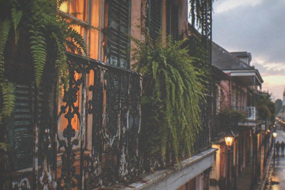 Wrought iron balcony detail on a French Quarter building at dusk