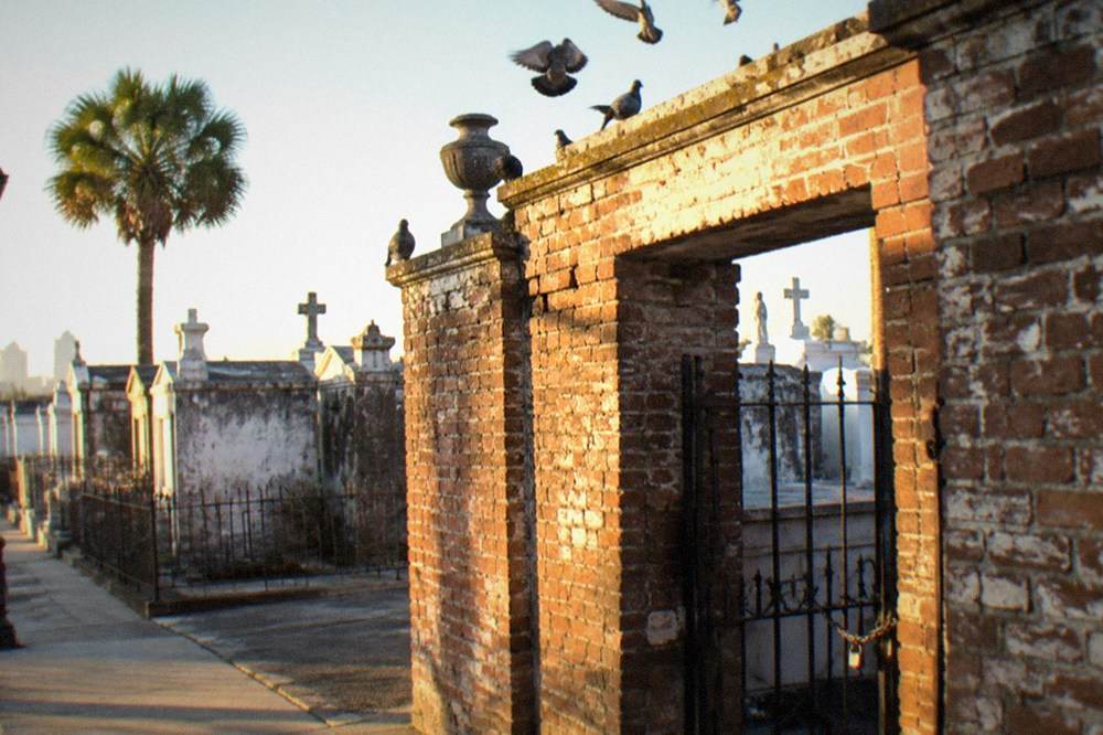 A brick gateway entrance to a historic New Orleans cemetery in daylight