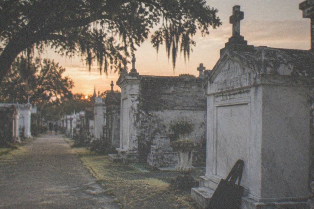 Above-ground stone tombs in a New Orleans cemetery in soft evening light