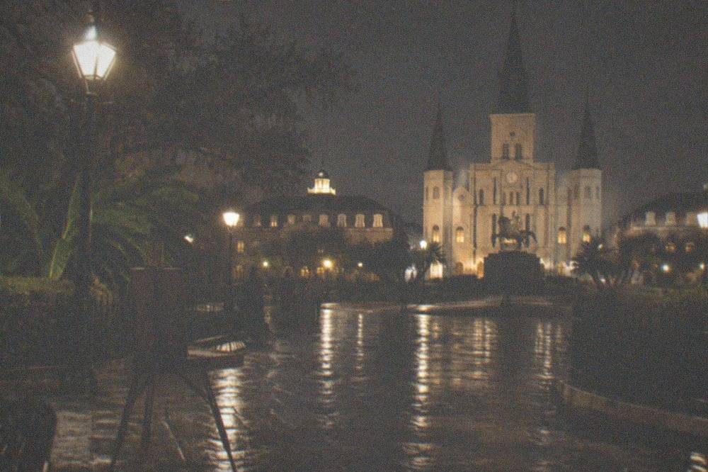 Illuminated corner of Jackson Square at night with the cathedral lit in the background