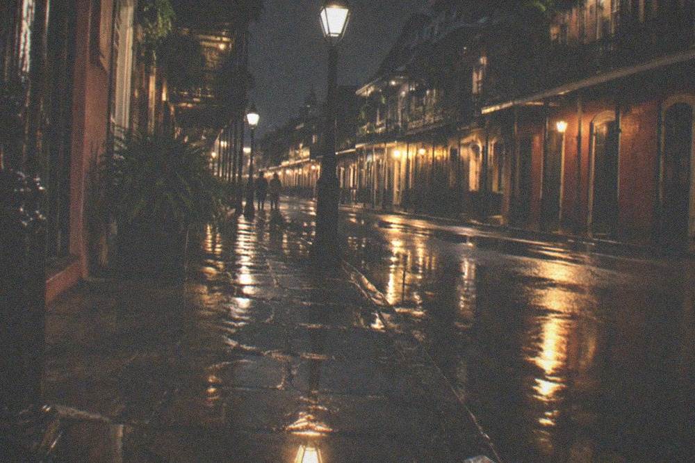 Rain-slicked French Quarter sidewalk reflecting streetlight at night